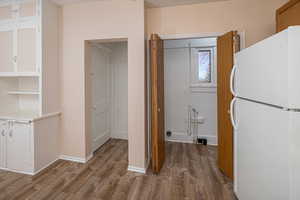 Main-floor laundry & kitchen with hardwood / wood-style floors and basement entry door