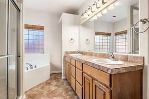 Bathroom featuring vanity and separate shower and tub