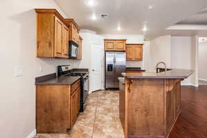 Kitchen with a kitchen breakfast bar, appliances with stainless steel finishes, sink, and an island with sink