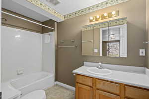 Full bathroom with toilet, vanity, bathtub / shower combination, and a textured ceiling