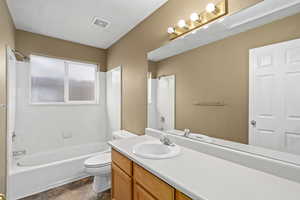 Full bathroom featuring bathtub / shower combination, toilet, and vanity