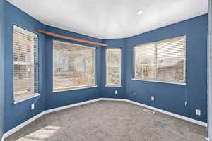 Carpeted empty room featuring a textured ceiling