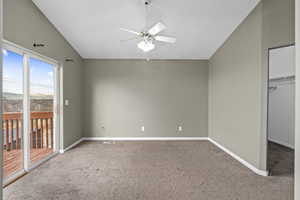 Unfurnished bedroom featuring carpet flooring, a closet, access to outside, vaulted ceiling, and ceiling fan