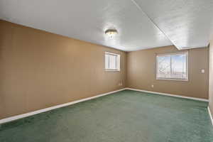 Carpeted empty room with a textured ceiling