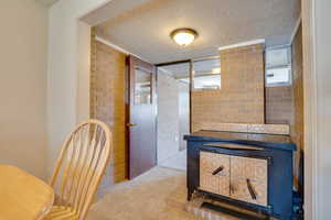 Hall featuring a textured ceiling and carpet flooring