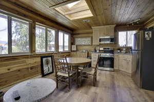 Interior space with wooden walls, light wood-type flooring, a skylight, wood ceiling, and track lighting