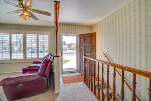 Foyer featuring carpet floors and ceiling fan