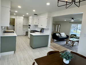 Kitchen featuring beautiful quartz countertop, black sink, white cabinetry, and tasteful backsplash