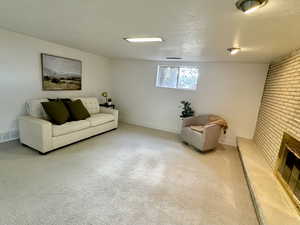 Carpeted living room featuring a textured ceiling and a fireplace