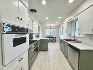 Kitchen featuring stainless steel appliances, tasteful backsplash, sink, a chandelier, and green cabinetry