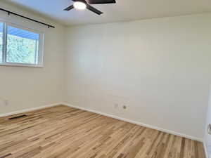 master bedroom with ceiling fan and light hardwood / wood-style flooring