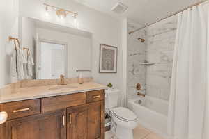 Full bathroom featuring shower / bath combination with curtain, vanity, and toilet