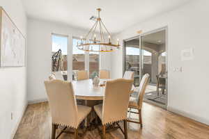 Dining area with an inviting chandelier and wood-type flooring