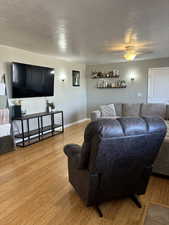 Living room featuring ceiling fan and light hardwood / wood-style flooring