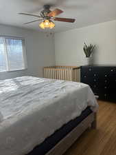 Bedroom with ceiling fan and hardwood / wood-style floors