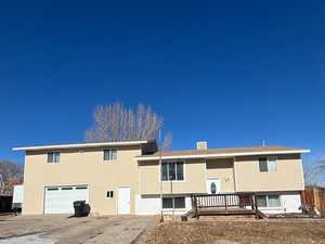 Front view of property featuring a deck and a garage