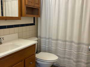 Bathroom with tile walls, toilet, and vanity