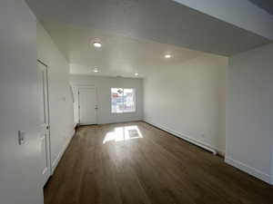 Great room with a baseboard heating unit and dark hardwood / wood-style flooring