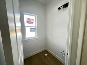 1/2 bath on main floor with dark wood-type flooring