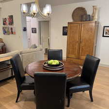 Dining space with light wood-style flooring, visible vents, a chandelier, and baseboards