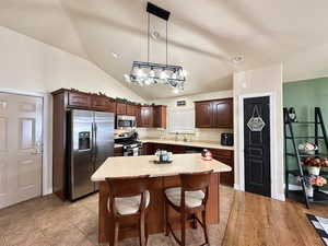 Kitchen featuring island and stainless steel appliances.  Pendulum lights.