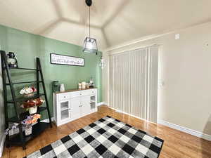 Dining area with light hardwood / wood-style floors and vaulted ceiling