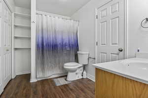 Bathroom featuring wood-type flooring, toilet, and vanity