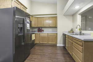 Kitchen with dishwasher, sink, black fridge with ice dispenser, range with electric cooktop, and dark hardwood / wood-style flooring