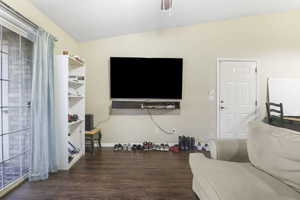 Living room with vaulted ceiling and dark hardwood / wood-style flooring