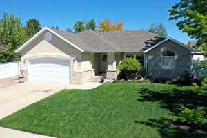Single story home featuring a front yard, a shingled roof, a garage, brick siding, and concrete driveway