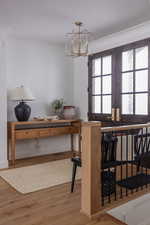 Dining room with crown molding, hardwood / wood-style floors, and a notable chandelier