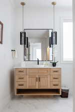 Bathroom with ornamental molding and vanity