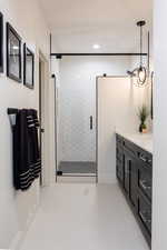 Bathroom with a shower with door, vanity, and tile patterned flooring