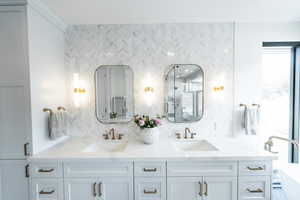 Bathroom with double vanity, tasteful backsplash, a shower with shower door, and a freestanding tub