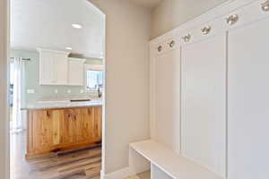 Mudroom featuring light wood-type flooring, a textured ceiling, and sink