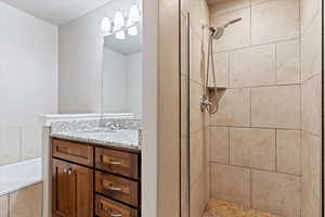 Bathroom featuring vanity and plus walk in shower