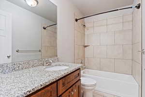 Full bathroom featuring toilet, tiled shower / bath, tile patterned floors, a textured ceiling, and vanity