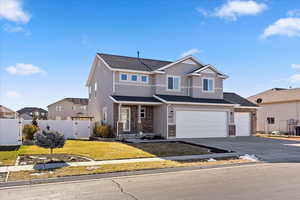 View of front of property with a front lawn and a garage