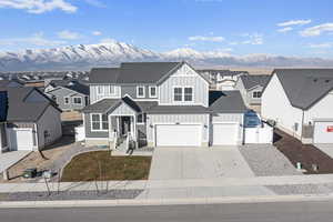 View of front of home with central AC, a mountain view, and a garage