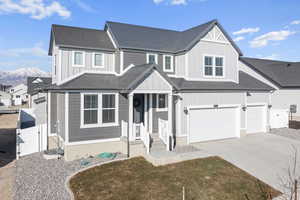 View of front facade featuring a garage, a front yard, and a mountain view