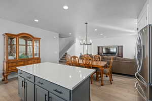 Kitchen featuring pendant lighting, a center island, light hardwood / wood-style floors, stainless steel fridge, and gray cabinetry