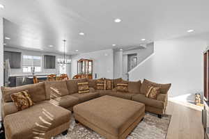 Living room with a notable chandelier and light wood-type flooring