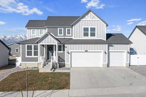 View of front of home with a front lawn, a garage, and a mountain view