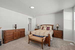 Bedroom featuring light carpet