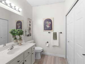 Bathroom with toilet, vanity, and hardwood / wood-style floors