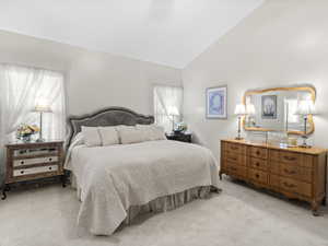 Carpeted bedroom with high vaulted ceiling