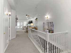 Hall featuring lofted ceiling and light colored carpet