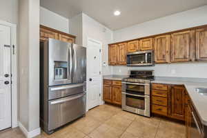 Kitchen with light tile patterned floors and stainless steel appliances