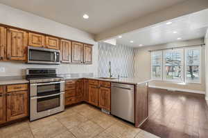 Kitchen featuring kitchen peninsula, appliances with stainless steel finishes, and sink