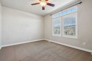 Spare room featuring ceiling fan and carpet floors